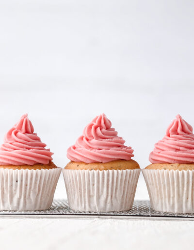 Three cupcakes with a pink topping